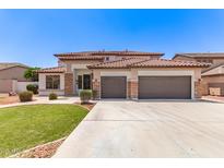 Charming two-story home boasts a three-car garage, well-manicured lawn, and beautiful desert landscaping at 135 E Julian Dr, Gilbert, AZ 85295