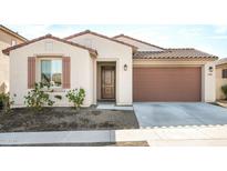 Single-story home with two-car garage, neutral color palette, and landscaping at 17849 W Thistle Landing Dr, Goodyear, AZ 85338