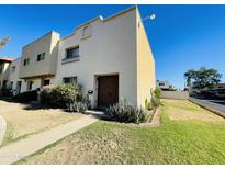 White stucco condo with a double door entry and well-maintained landscaping at 1924 W Hazelwood W Pkwy, Phoenix, AZ 85015