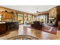 Open concept kitchen and living area with a stone fireplace at 18626 E Amarado Cir, Rio Verde, AZ 85263