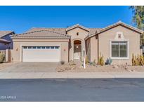 Tan house with a white garage door and desert landscaping at 4918 E Michigan Ave, Scottsdale, AZ 85254