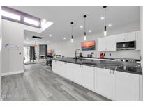 Modern kitchen with white cabinets, black countertops, and stainless steel appliances at 7663 E Pleasant Run, Scottsdale, AZ 85258