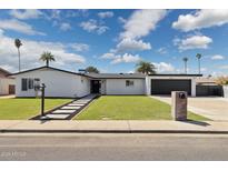 Charming single-story home with a well-manicured lawn and black rock landscaping at 2265 E Elmwood St, Mesa, AZ 85213