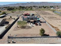 Expansive aerial view of desert property with custom home, pool, horse facilities, and mountain views at 7214 N 183Rd Ave, Waddell, AZ 85355