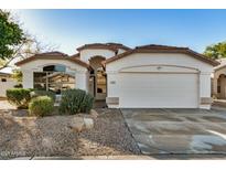 Single-story home with a two-car garage and well-maintained landscaping at 9829 E Onza Ave, Mesa, AZ 85212