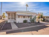 White single-wide manufactured home with carport and small front yard at 201 S Greenfield Rd # 142, Mesa, AZ 85206