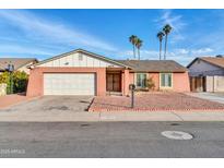 Ranch style home with a two-car garage and desert landscaping at 6934 W Orange Dr, Glendale, AZ 85303