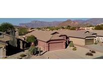 Aerial view of a charming single-story house with a two-car garage, desert landscaping, and mountain views at 8944 E Red Mountain Ln, Gold Canyon, AZ 85118