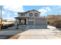 Two-story house with gray siding, a three-car garage, and a landscaped front yard at 18225 W Foothill Dr, Surprise, AZ 85387