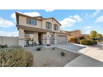 Two-story house with gray siding, a two-car garage, and a landscaped front yard at 18225 W Foothill Dr, Surprise, AZ 85387