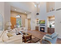 Spacious living room featuring hardwood floors, a fireplace, and ample natural light at 20802 N Grayhawk Dr # 1053, Scottsdale, AZ 85255