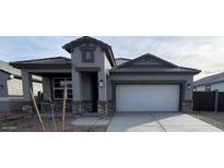 New single-story home with gray exterior, stone accents, and a two-car garage at 25431 W Graham Trl, Buckeye, AZ 85326