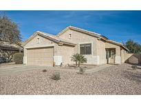 Single-story house with a two-car garage and desert landscaping at 15436 W Port Royale Ln, Surprise, AZ 85379