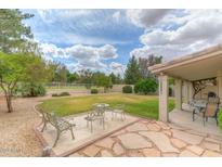 Spacious backyard with patio, grass, and mature trees at 6413 W Irma Ln, Glendale, AZ 85308