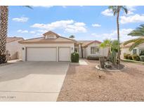 Two-car garage, desert landscaping, and light-colored exterior at 10833 E Flintlock Dr, Sun Lakes, AZ 85248