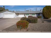 Single story home with a two-car garage and well-maintained landscaping at 11034 W Alabama Ave, Sun City, AZ 85351