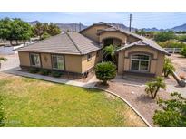 Tan two-story house with tile roof, landscaping, and driveway at 20811 E Excelsior Ave, Queen Creek, AZ 85142