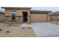 Charming single-Gathering home featuring stone accents, a two-car garage, and desert landscaping at 24177 W Hilton Ave, Buckeye, AZ 85326