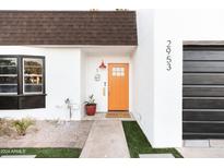 Mid-century modern home with orange door, dark garage door, and landscaping at 2953 S Country Club Way, Tempe, AZ 85282