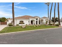 Stunning single-story home featuring a well-manicured lawn and a beautiful white stucco exterior with a tile roof at 321 N Portland Ave, Gilbert, AZ 85234