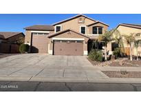 Two-story house with a three-car garage and landscaped front yard at 15936 W Canterbury Dr, Surprise, AZ 85379