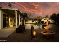 Backyard featuring a fountain, palm trees, and desert landscaping at 17765 W Summit Dr, Goodyear, AZ 85338