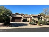 Tan house with a brown double garage door and desert landscaping at 2316 W Sax Canyon Ln, Phoenix, AZ 85086