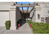 Inviting home exterior with a walkway, lush landscaping, and a charming pergola at 6248 E Aire Libre Ln, Scottsdale, AZ 85254