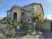 Two-story house with arched entryway, landscaping, and a light brown exterior at 10617 W La Reata Ave, Avondale, AZ 85392