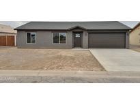 New single-story house with gray exterior, brown garage door, and small front yard at 10073 W Mission Dr, Arizona City, AZ 85123