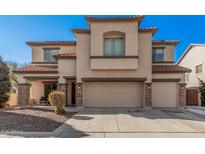 Two-story house with a large front yard and attached two-car garage at 14570 N 142Nd Ln, Surprise, AZ 85379