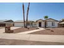 White single story home with a two car garage, landscaped yard, and walkway at 1527 W Rosemonte Dr, Phoenix, AZ 85027