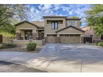 Two-story house with stone accents and a three-car garage at 15526 W Minnezona Ave, Goodyear, AZ 85395