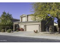 Two-story house with tan exterior, landscaped yard, and two-car garage at 1240 W Falls Canyon Dr, Casa Grande, AZ 85122