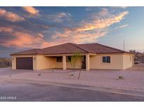 Beautiful single-story home boasts a symmetrical facade, neutral color palette, desert landscaping, and a terracotta tile roof at 125 Ironwood Pl, Wickenburg, AZ 85390