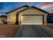 One-story house with light beige exterior, a two-car garage, and rock landscaping at 12962 W Catalina Dr, Avondale, AZ 85392