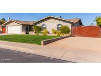 Single story home with attached garage, landscaped lawn, and gated driveway at 1638 E Hackamore St, Mesa, AZ 85203