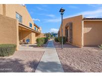 Neat pathway leads to the condo building, with manicured landscaping at 3511 E Baseline Rd # 1243, Phoenix, AZ 85042