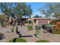 Desert landscape surrounds this one-story home with a large garage and stucco exterior at 18300 E Tonto Verde Dr, Rio Verde, AZ 85263