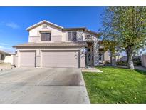 Two-story house with three-car garage and manicured lawn at 20997 N 79Th Ave, Peoria, AZ 85382