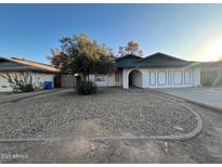 Ranch style home with a two-car garage and a rock front yard at 2829 W Morten Ave, Phoenix, AZ 85051