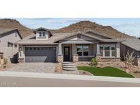 Charming single-story home featuring a stone-accented facade, gray exterior, and well-manicured landscaping at 32496 N 135Th Dr, Peoria, AZ 85383