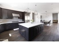 Gourmet kitchen with island, stainless steel appliances, and dark cabinetry at 3928 E Crittenden Ln, Phoenix, AZ 85018