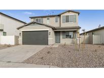 Two-story house with gray siding, a two-car garage, and a landscaped front yard at 5018 W Walatowa St, Laveen, AZ 85339