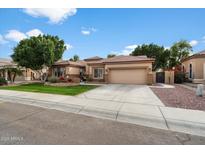 Single-story home with landscaped front yard, two-car garage, and inviting curb appeal at 7167 W Trails Dr, Glendale, AZ 85308