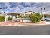 Single-wide manufactured home with carport and nicely landscaped front yard at 7750 E Broadway Rd # 674, Mesa, AZ 85208