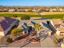 Aerial view of a house and neighborhood with a golf course nearby at 13708 W Robertson Dr, Sun City West, AZ 85375