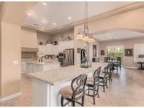 Gourmet kitchen boasts expansive island, stainless steel appliances, and ample cabinetry at 1534 E Sweet Citrus Dr, Queen Creek, AZ 85140