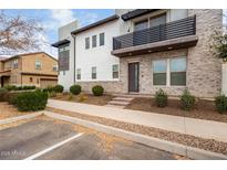 Modern two-story home with stone accents and a balcony at 1685 S Wallrade Ln, Gilbert, AZ 85295