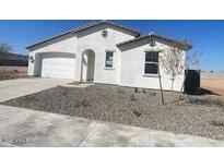 New construction home with a two-car garage and desert landscaping at 18950 W Stella Ave, Waddell, AZ 85355